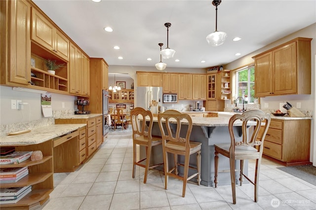 21414 137th Ave NE, Arlington, WA 98223 - kitchen with open shelves, stainless steel appliances, light stone counters, a kitchen island, and a breakfast bar