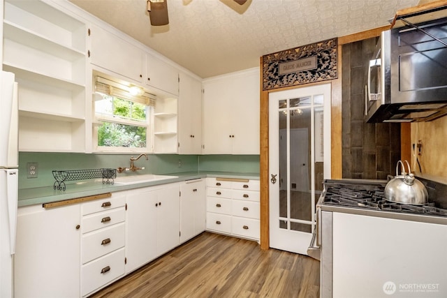 6711 100th St SW, Lakewood, WA 98499 - kitchen featuring open shelves, stainless steel appliances, light wood-style flooring, ceiling fan, and white cabinets