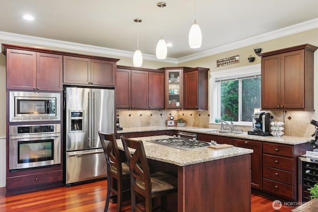 26713 178th Loop SE, Covington, WA 98042 - kitchen with appliances with stainless steel finishes, glass insert cabinets, dark wood-type flooring, a center island, and decorative light fixtures