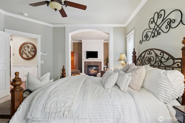 26713 178th Loop SE, Covington, WA 98042 - bedroom with crown molding, a tiled fireplace, a ceiling fan, and arched walkways