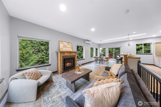 3 River Ridge Loop, Bellingham, WA 98229 - living room featuring light wood-type flooring, recessed lighting, a wall unit AC, a tiled fireplace, and a skylight