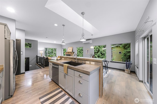 3 River Ridge Loop, Bellingham, WA 98229 - kitchen with stainless steel appliances, a wall mounted air conditioner, an island with sink, light wood-style floors, and recessed lighting