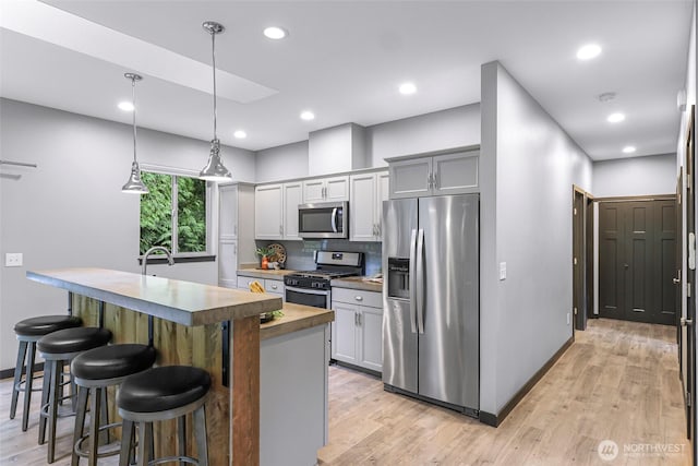 3 River Ridge Loop, Bellingham, WA 98229 - kitchen with appliances with stainless steel finishes, backsplash, a kitchen breakfast bar, light wood-type flooring, and recessed lighting