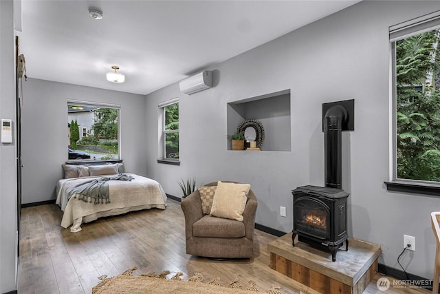 3 River Ridge Loop, Bellingham, WA 98229 - bedroom featuring a wood stove, a wall mounted air conditioner, and hardwood / wood-style floors
