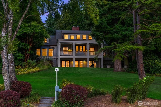 3639 Hunts Point Rd, Hunts Point, WA 98004 - back of property at dusk with a chimney and a yard
