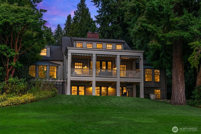 3639 Hunts Point Rd, Hunts Point, WA 98004 - back of house at dusk featuring a chimney, a yard, french doors, and a balcony