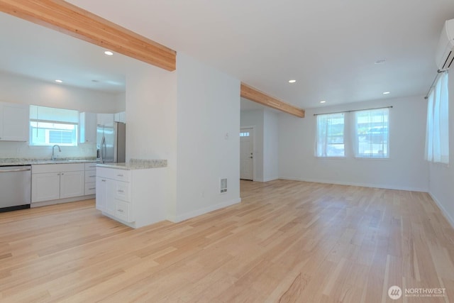 18768 1st Ave NE, Suquamish, WA 98392 - unfurnished living room featuring light wood-type flooring, beam ceiling, and recessed lighting