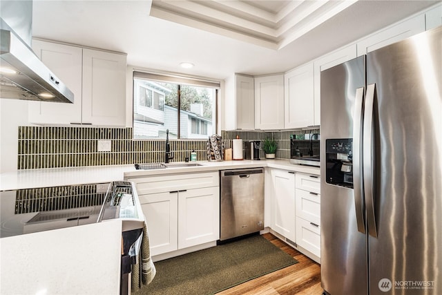 830 S 301st Pl, Federal Way, WA 98003 - kitchen with stainless steel appliances, wall chimney exhaust hood, white cabinets, light countertops, and wood finished floors