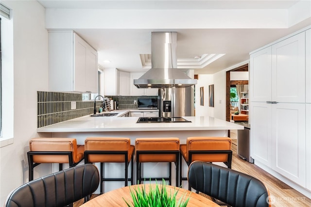 830 S 301st Pl, Federal Way, WA 98003 - kitchen with island exhaust hood, decorative backsplash, white cabinets, light countertops, and plenty of natural light