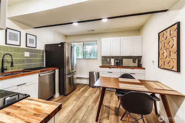 830 S 301st Pl, Federal Way, WA 98003 - kitchen featuring appliances with stainless steel finishes, wooden counters, white cabinets, light wood-type flooring, and tasteful backsplash
