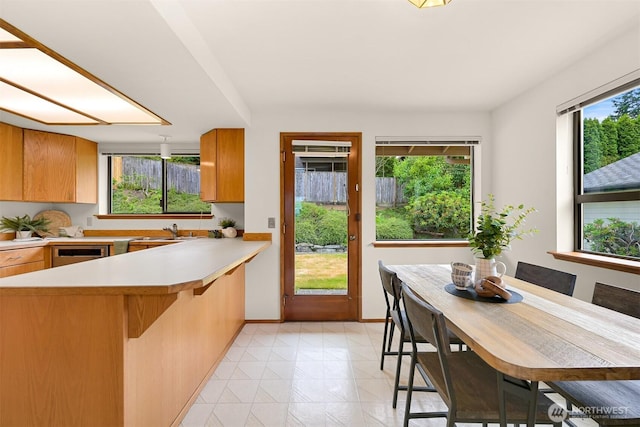 1708 Whatcom St, Bellingham, WA 98229 - kitchen with light countertops, a kitchen bar, brown cabinets, and a peninsula