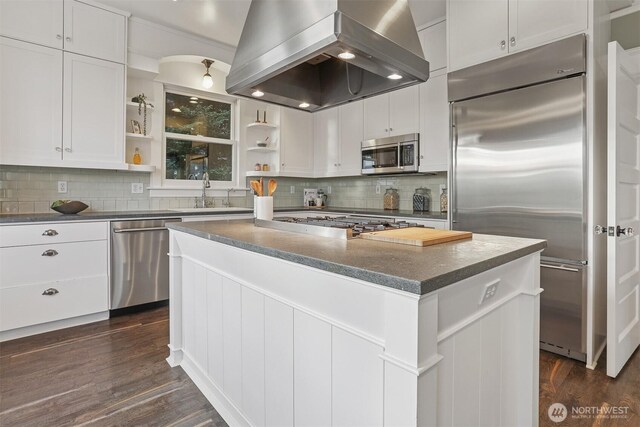 4117 44th Ave SW, Seattle, WA 98116 - kitchen featuring exhaust hood, appliances with stainless steel finishes, open shelves, dark wood-style floors, and a center island