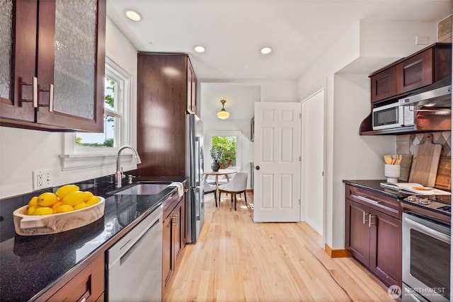 6543 12th Ave NW, Seattle, WA 98117 - kitchen with stainless steel appliances, light wood-style flooring, healthy amount of natural light, dark stone counters, and recessed lighting