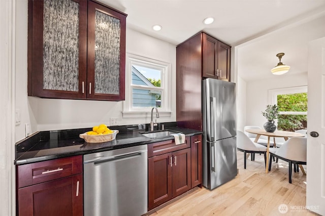 6543 12th Ave NW, Seattle, WA 98117 - kitchen featuring appliances with stainless steel finishes, light wood-style flooring, dark stone countertops, and recessed lighting