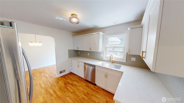 1303 Modoc, Walla Walla, WA 99362 - kitchen with appliances with stainless steel finishes, decorative backsplash, light wood-style floors, white cabinets, and light stone countertops