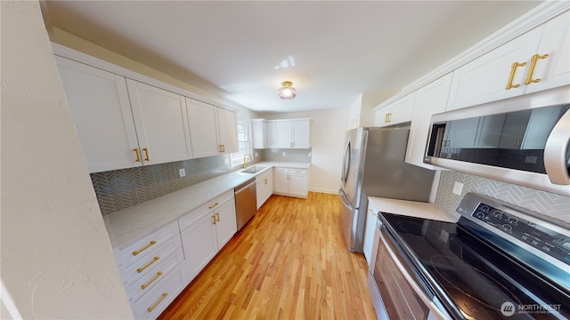 1303 Modoc, Walla Walla, WA 99362 - kitchen with stainless steel appliances, tasteful backsplash, light wood-type flooring, and white cabinetry