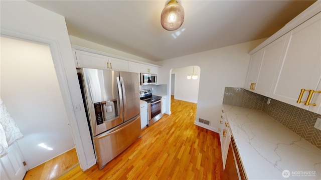1303 Modoc, Walla Walla, WA 99362 - kitchen with appliances with stainless steel finishes, backsplash, white cabinetry, light wood-type flooring, and light stone counters