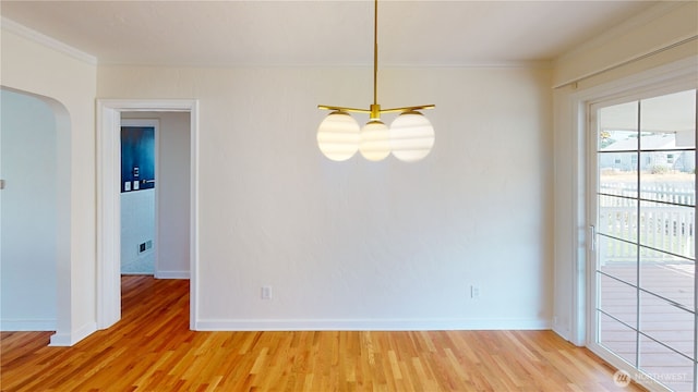 1303 Modoc, Walla Walla, WA 99362 - unfurnished dining area with arched walkways, crown molding, and light wood-style flooring