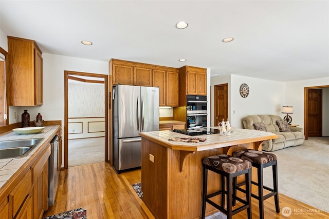 24131 SE 225th St, Maple Valley, WA 98038 - kitchen featuring stainless steel appliances, tile counters, open floor plan, a center island, and a kitchen bar