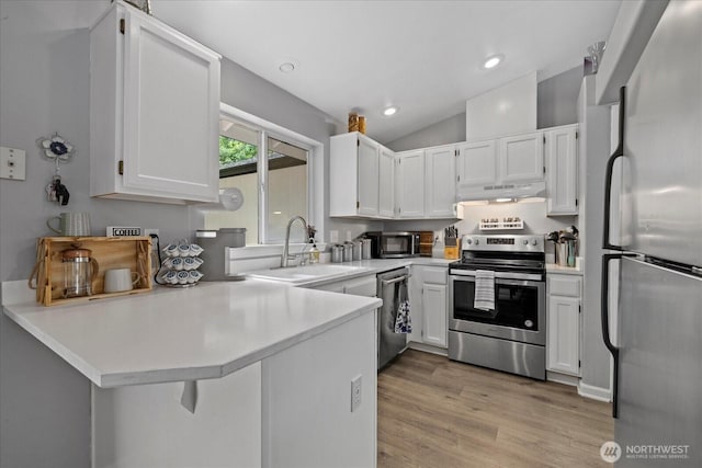 35728 157th Pl SE, Sultan, WA 98294 - kitchen with stainless steel appliances, under cabinet range hood, a peninsula, white cabinets, and vaulted ceiling