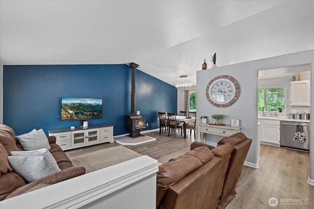 35728 157th Pl SE, Sultan, WA 98294 - living area with a wood stove, light wood-style flooring, lofted ceiling, and a chandelier