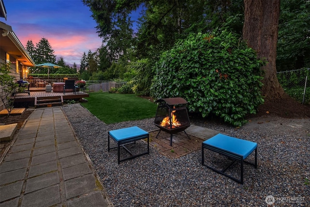 23318 3rd Pl W, Bothell, WA 98021 - patio terrace at dusk with an outdoor fire pit, a wooden deck, a fenced backyard, and a patio area