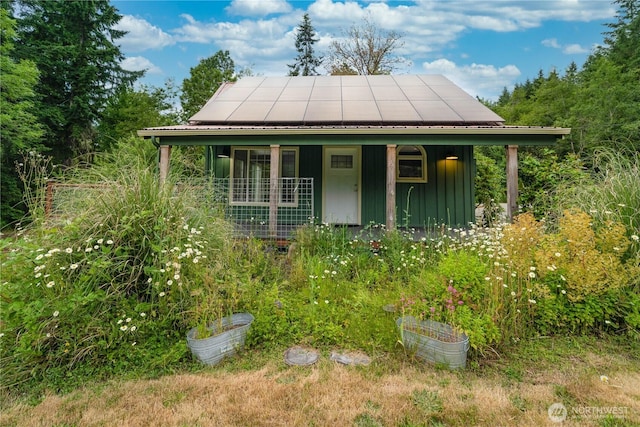 21405 Thompson Creek Rd SE, Tenino, WA 98589 - view of front of house featuring roof mounted solar panels, board and batten siding, and a porch