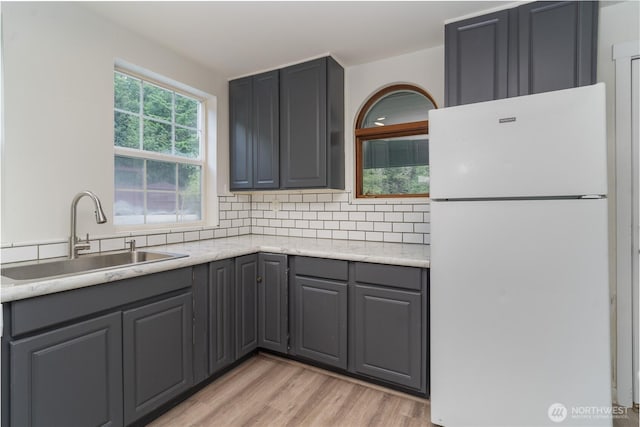 21405 Thompson Creek Rd SE, Tenino, WA 98589 - kitchen with freestanding refrigerator, gray cabinets, backsplash, and light wood-type flooring