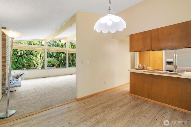 3909 Fielding Ave, Bellingham, WA 98229 - kitchen featuring stainless steel refrigerator with ice dispenser, brown cabinets, light wood finished floors, cooktop, and decorative light fixtures