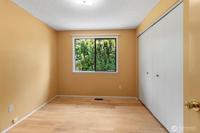 3909 Fielding Ave, Bellingham, WA 98229 - unfurnished bedroom featuring light wood-style floors, a closet, and a textured ceiling