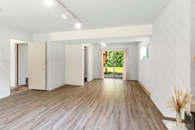 3909 Fielding Ave, Bellingham, WA 98229 - unfurnished room featuring wallpapered walls, wood finished floors, a baseboard radiator, and track lighting