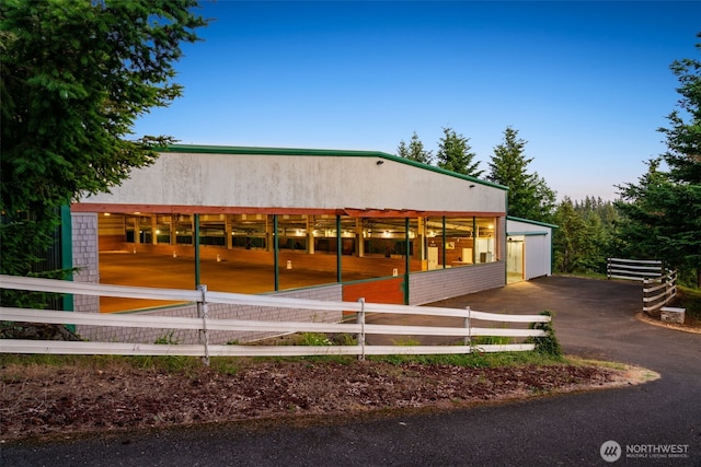 view of front of house with a riding arena and an outdoor structure