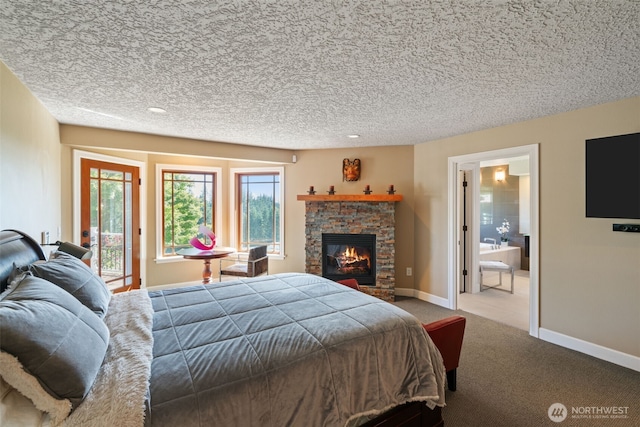 carpeted bedroom featuring a fireplace, a textured ceiling, access to outside, and ensuite bathroom