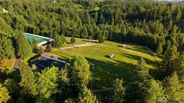 aerial view of property and surrounding area with a heavily wooded area