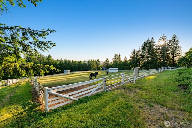view of yard featuring a rural view and an outbuilding