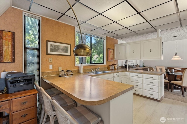 4925 Goodpiper Ln, Freeland, WA 98249 - kitchen featuring a peninsula, white cabinets, pendant lighting, light countertops, and a paneled ceiling