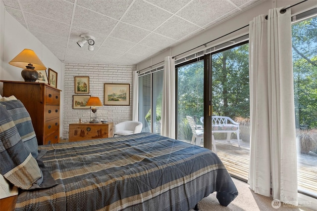 4925 Goodpiper Ln, Freeland, WA 98249 - carpeted bedroom with access to exterior, a paneled ceiling, and brick wall