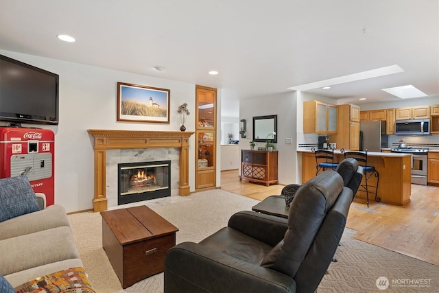 7123 NE 165th St, Kenmore, WA 98028 - living area featuring a tile fireplace, a skylight, recessed lighting, and light wood-style flooring