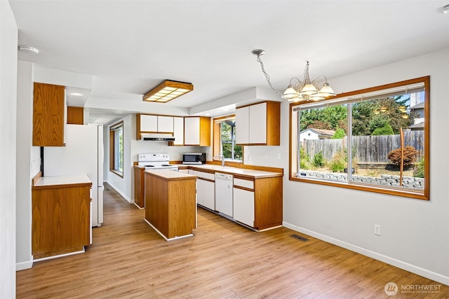 9812 S 247th Ct, Kent, WA 98030 - kitchen featuring white appliances, under cabinet range hood, light countertops, a center island, and a chandelier