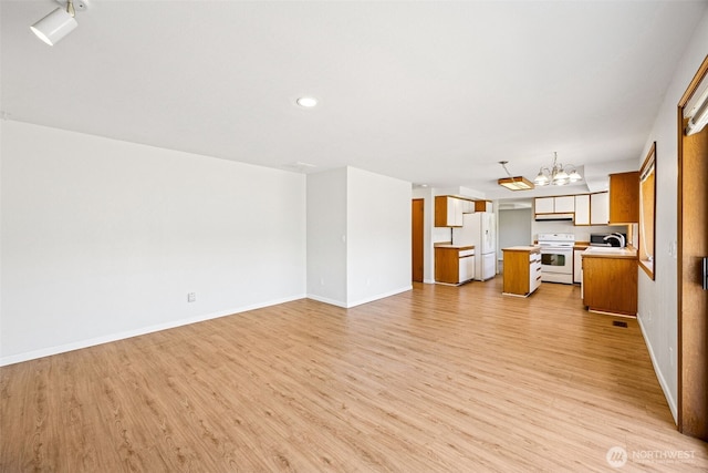 9812 S 247th Ct, Kent, WA 98030 - unfurnished living room with a chandelier, light wood-style flooring, and recessed lighting