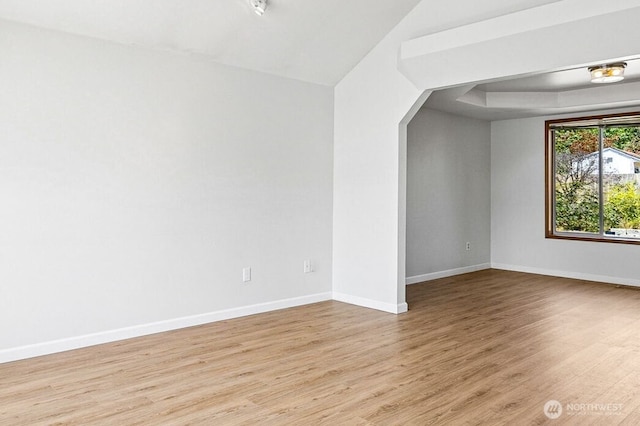 9812 S 247th Ct, Kent, WA 98030 - spare room with light wood-style flooring, arched walkways, and a raised ceiling