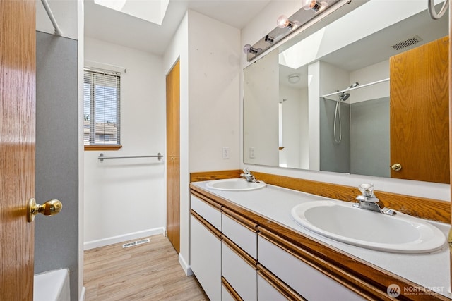 9812 S 247th Ct, Kent, WA 98030 - full bathroom with a skylight, wood finished floors, and double vanity
