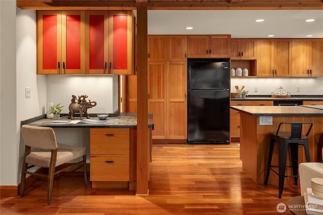 2339 Fairview Ave E Unit L, Seattle, WA 98102 - kitchen featuring freestanding refrigerator, light wood-style floors, a kitchen bar, dark countertops, and recessed lighting