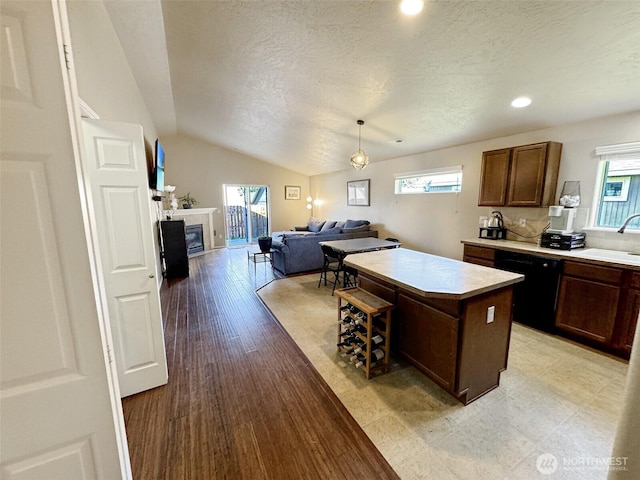 314 SW Homestead, College Place, WA 99324 - kitchen featuring dishwasher, a textured ceiling, a kitchen island, lofted ceiling, and light countertops