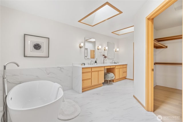 4811 Somerset Dr SE, Bellevue, WA 98006 - bathroom with double vanity, a walk in closet, a soaking tub, marble finish floors, and a skylight