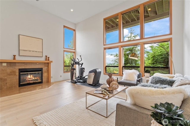 4811 Somerset Dr SE, Bellevue, WA 98006 - living area with wood finished floors, a tiled fireplace, a towering ceiling, and recessed lighting