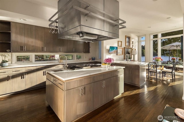 3611 Hunts Point Rd, Hunts Point, WA 98004 - kitchen with exhaust hood, an island with sink, stainless steel gas cooktop, dark wood finished floors, and open shelves