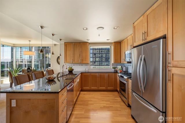 10610 NE 9th Pl Unit 1220, Bellevue, WA 98004 - kitchen featuring stainless steel appliances, a peninsula, light wood finished floors, tasteful backsplash, and dark stone counters