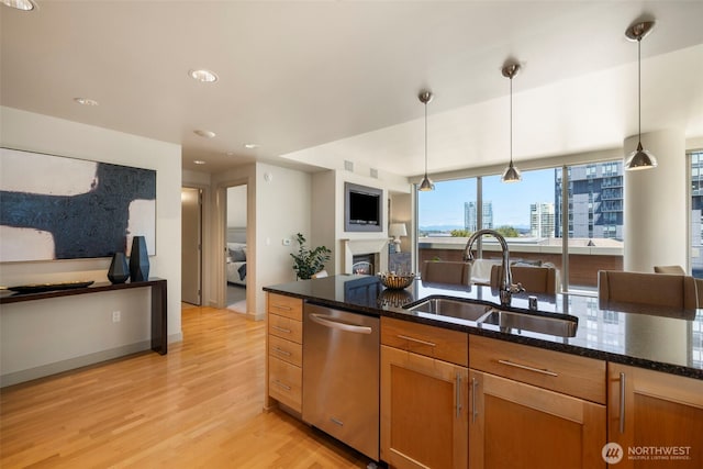 10610 NE 9th Pl Unit 1220, Bellevue, WA 98004 - kitchen with stainless steel dishwasher, light wood-style floors, dark stone counters, a lit fireplace, and recessed lighting
