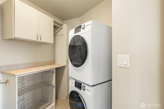 10610 NE 9th Pl Unit 1220, Bellevue, WA 98004 - washroom featuring estacked washer and dryer, cabinet space, and light tile patterned floors